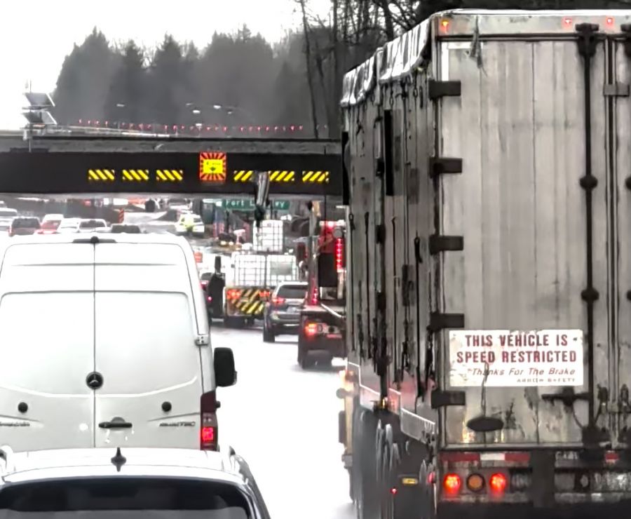 <who>Photo Credit: BC Highway Patrol</who>A boom on the load of the white flat deck truck in the centre of this photo struck the CP Rail overpass over Hwy 1 in Langley.