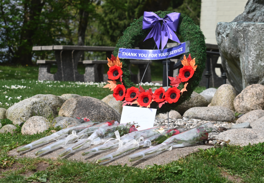 <who> Photo credit: Abby Luciano / North Shore News </who> Six roses and a letter to the victims sit in front of a wreath following Thursday's ceremony.