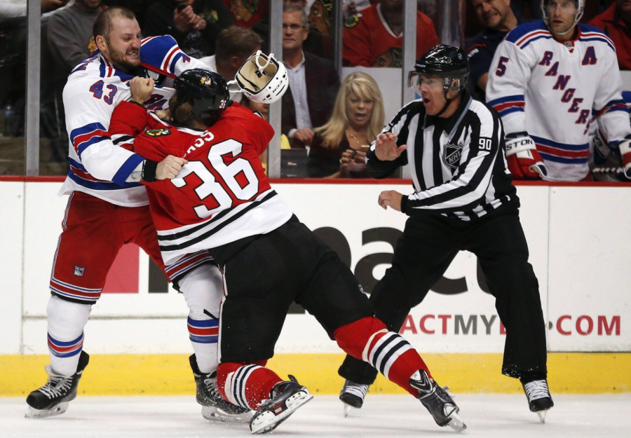 <who> (AP Photo/Andrew A. Nelles) Andrew Nelles </who> New York Rangers forward Nick Tarnasky (43) and Chicago Blackhawks centre Cody Bass (36) fight as linesman Andy McElman looks on during the first period of a preseason NHL hockey game on Friday, Sept. 26, 2014, in Chicago.