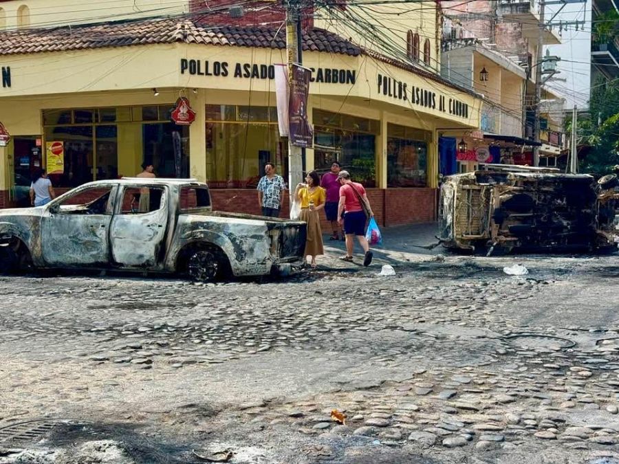</who>Burnt-out and tipped-on-its-side vehicles.