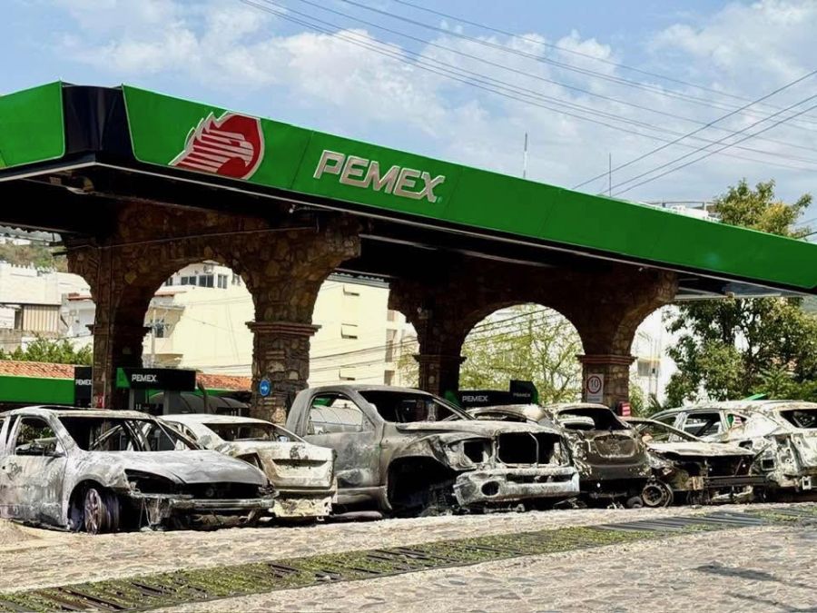 </who>Above, lined up and torched cars at a gas station. Below, rubble blocks the sidewalk.