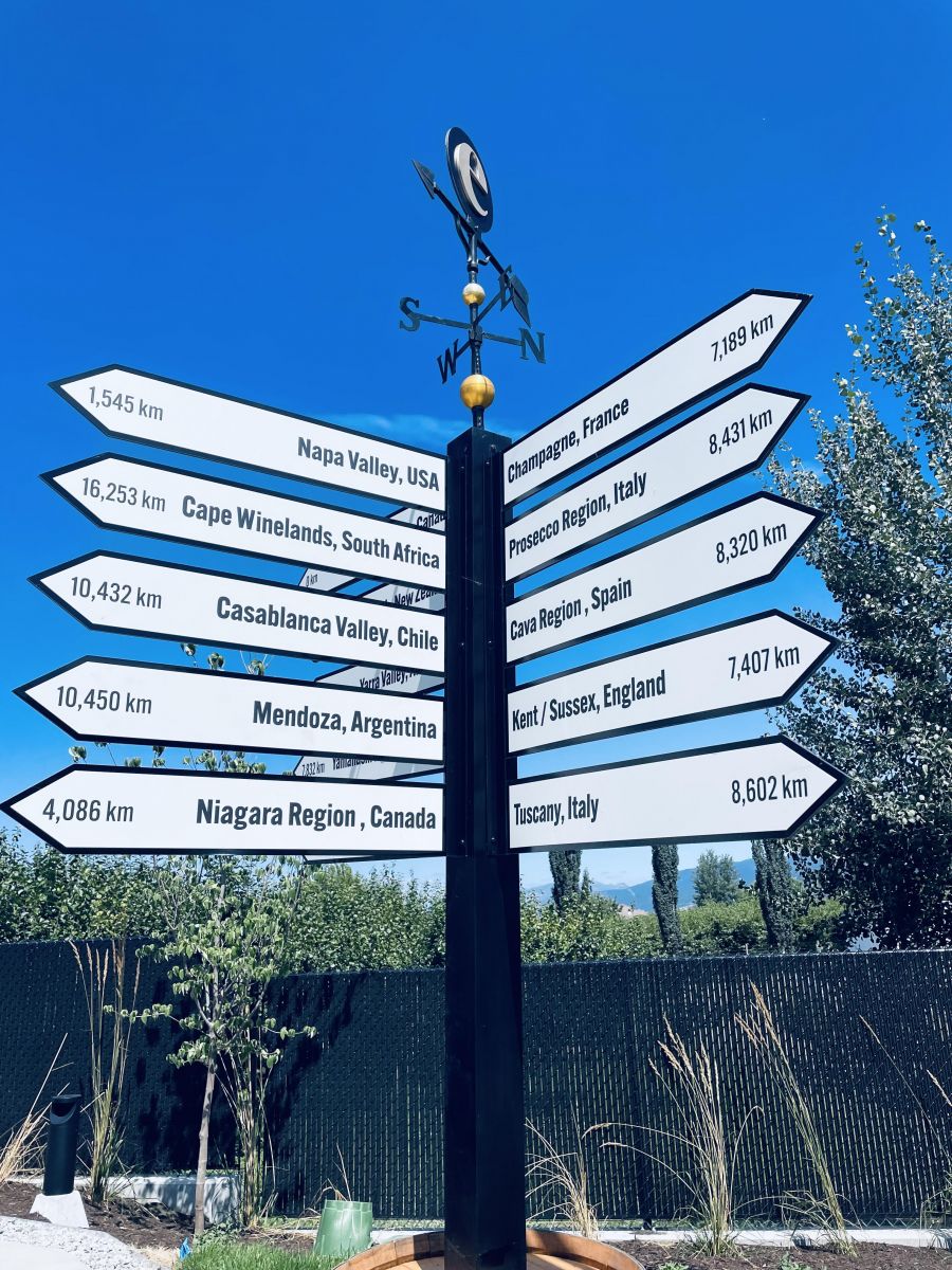 </who>Directional signs pointing to sparkling wine producing regions around the world.
