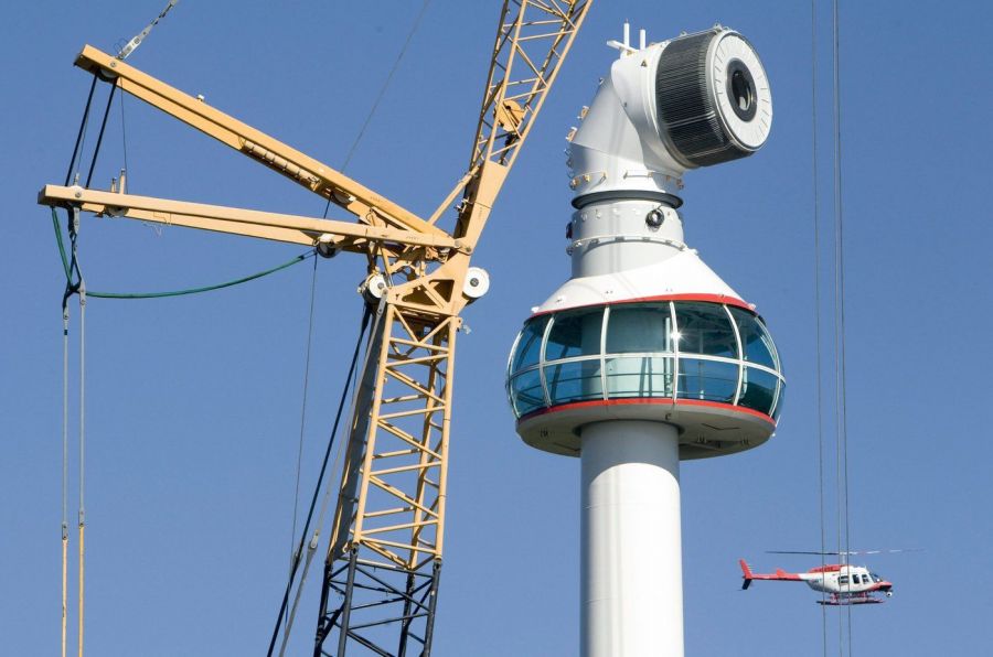 <who>Photo Credit: Canadian Press</who>A news helicopter flies by as a 130-ton all-terrain crane prepares to place the giant blades onto a massive wind turbine on the top of Grouse Mountain ski resort in North Vancouver in 2009.